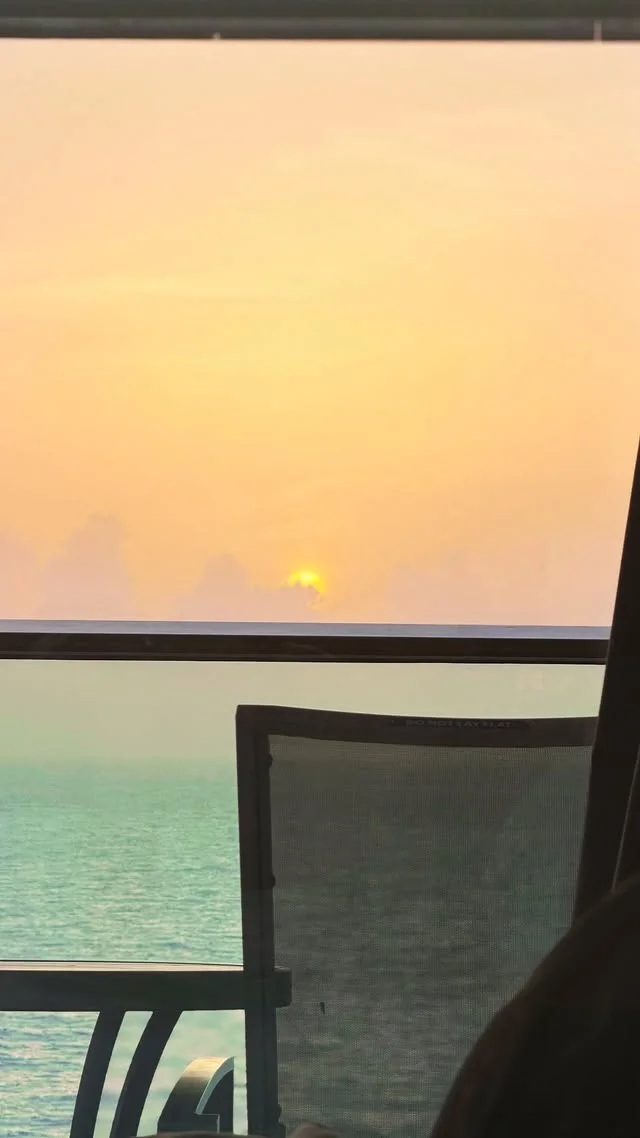 Sunset over the sea seen through a balcony railing
